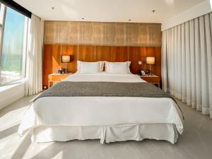 里约热内卢Hotel Nacional Rio de Janeiro - OFICIAL的一间卧室设有一张大床和一个大窗户