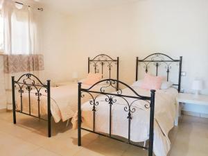 西尼斯科拉Home Garden的一间卧室配有黑色金属床和粉红色枕头
