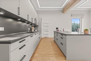 巴斯克卡拉奇Lénger Schoul的一间铺有木地板的大厨房,配有白色的橱柜