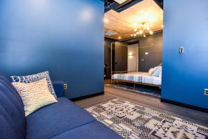 米德尔敦Indigo Pass Boutique Hotel的一间带蓝色沙发的客厅和一间卧室