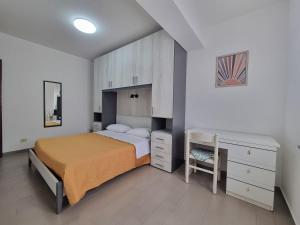 克罗帕尼Villaggio Camping Lungomare的一间卧室配有一张床、梳妆台和书桌