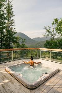 圣安娜德蒙Auberge de Montagne des Chic-Chocs Mountain Lodge - Sepaq的甲板上热水浴池中的女人