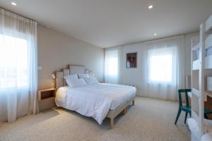 圣特罗让莱班勒斯宾酒店的卧室配有白色的床和2扇窗户。