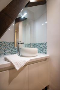 萨尔拉拉卡内达Les Chambres du "Coup de Coeur de Sarlat"的一间带水槽和镜子的浴室