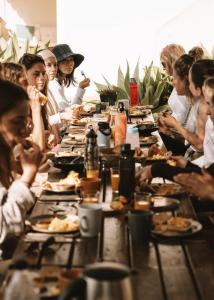 卢斯Mirabilia Luz - Altavista的一群坐在长桌旁吃食物的人