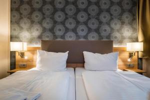 柏林阿尔特市场酒店的酒店的客房内设有两张带白色枕头的床。