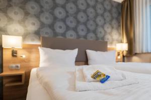 柏林阿尔特市场酒店的卧室配有白色床和毛巾
