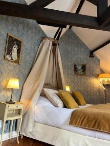 滨海布洛涅Chambres d'hôtes du château的一间卧室配有一张带天蓬的床