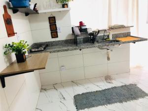 里约热内卢lindo apartamento no recreio bem pertinho da praia的厨房配有大理石台面和水槽