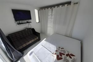 里约热内卢lindo apartamento no recreio bem pertinho da praia的一间白色的小房间,配有电视和桌子