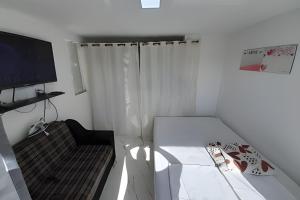 里约热内卢lindo apartamento no recreio bem pertinho da praia的小房间设有床和电视