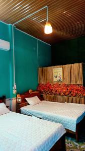Ấp Phú Thạnh (4)Let's go CAN THO - CAN THO FARMSTAY的一间设有两张床和绿色墙壁的客房