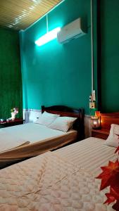 Ấp Phú Thạnh (4)Let's go CAN THO - CAN THO FARMSTAY的卧室设有两张床铺和绿色的墙壁