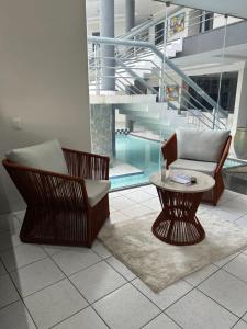 巴纳伊巴那提勒斯酒店的客厅设有两把椅子、一张桌子和一个游泳池