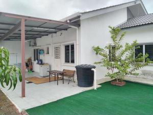 KaparMalay Homestay di Meru, Klang的白色的房子,设有配有桌子的庭院