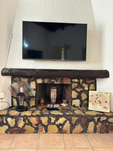 巴莱斯特拉泰Rifugio Giudeo的石制壁炉顶部的平面电视