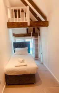 Hatfield Broad OakBARN: Sleeps 6, Stansted 12 mins的一间卧室配有带梯子的双层床