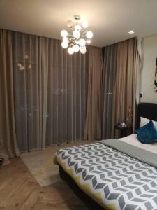 麦纳麦Era View Bahrain Luxurious 1 bedroom, Sea view and waterfront的一间卧室配有一张大床和一个吊灯。