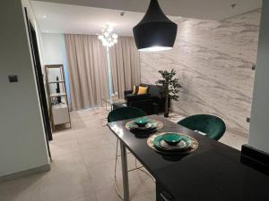 麦纳麦Era View Bahrain Luxurious 1 bedroom, Sea view and waterfront的客厅配有桌子和绿色椅子