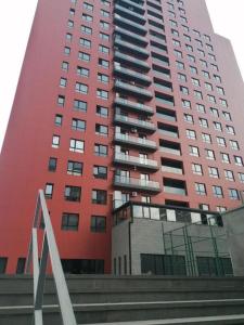 第比利斯A-Y Apartments P A4的一座高大的红色建筑,前面有楼梯