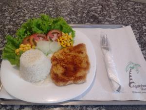 CarapicuíbaHotel Coqueiros 6的餐桌上放着一盘饭和蔬菜的食物