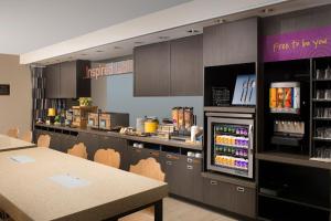 丹佛丹佛国际机场希尔顿欣庭套房酒店 的一间带柜台和桌子以及冰箱的餐厅