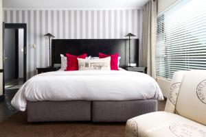 斯泰伦博斯Life & Leisure Boutique Guesthouse的一间卧室配有一张带红色枕头的大床