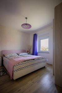 斯诺基Apartman Milka的一间卧室配有一张床和一个带紫色窗帘的窗户
