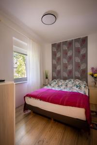 斯诺基Apartman Milka的一间卧室配有一张大床和紫色床罩