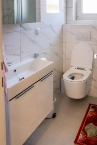 斯诺基Apartman Milka的白色的浴室设有卫生间和水槽。