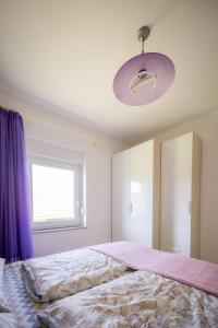斯诺基Apartman Milka的一间卧室配有一张带紫色窗帘的大床