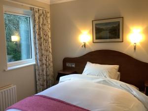 基拉尼格任菲亚乡间别墅酒店的一间卧室配有一张带两盏灯的床和一扇窗户。