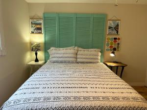 萨尼亚Modern Beach House long stay discounts的一间卧室配有一张大床和绿色床头板