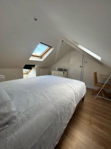 剑桥Blissful 1-bedroom entire place的卧室配有一张白色的大床和天窗。