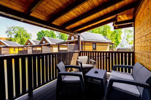 扎托尔Western Camp Resort的露台配有椅子和桌子,甲板上配有桌子