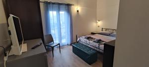 拉泰尔扎Casa vacanze Margherita的一间卧室配有一张带椅子的床和一扇窗户