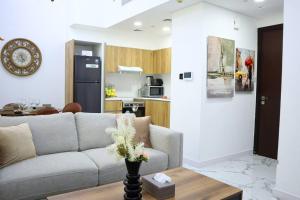 阿布扎比MasdarCity Bliss 2BR apartment的客厅配有沙发和桌子