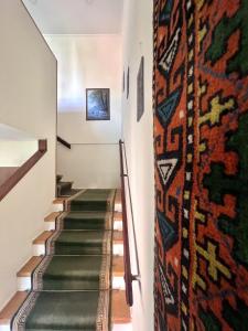 第比利斯Madera Hotel的走廊上设有楼梯,墙上挂着地毯