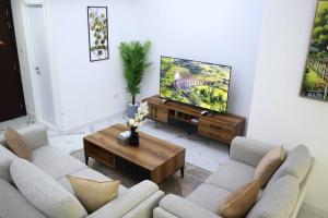 阿布扎比MasdarCity Bliss 2BR apartment的客厅配有2张沙发和1台平面电视