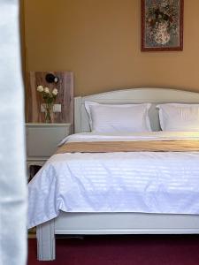 第比利斯Madera Hotel的卧室配有白色的床和花瓶