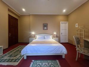 第比利斯Madera Hotel的一间卧室配有一张大床和两把椅子