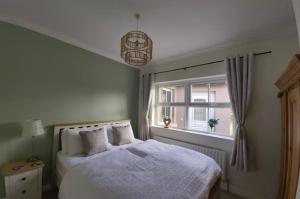 克利夫登Shanakeever Farm - 2 Bedroom Apartment的卧室配有白色的床和窗户。