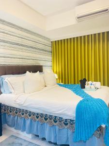 马尼拉Holiday Escape Philippines的卧室内的两张床,配有黄色窗帘