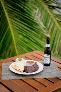 伯利兹城Casa Al Mar, St. George's Caye - Belize的一张桌子,上面放着一盘食物和一瓶啤酒