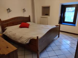 Settimo VittoneRelais del Brigante的一间卧室配有一张带红色枕头的木床