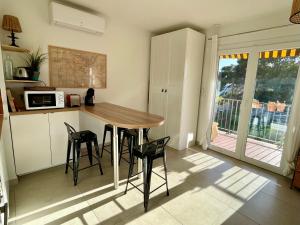 勒普拉代Appartement cosy vue mer à 50 m de la plage - refait à neuf et climatisé的一间厨房,里面配有桌椅