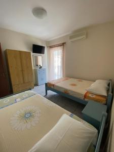 奥林匹亚基·阿克蒂Villa Ilias的一间卧室配有两张床和电视。