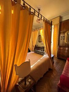 Venegono Superiore普契尼别墅度假屋的一间卧室配有橙色窗帘的床
