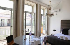 波尔图Palácio Fenizia Lux Apartments的卧室配有床、桌子和窗户。