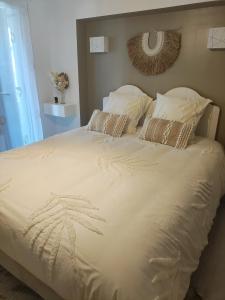巴苏萨赫Chambre d'hôtes kaxu的一张配有白色床单和枕头的大床